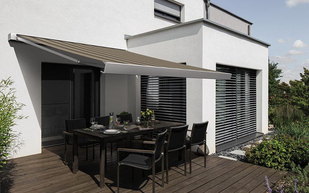 Terrasse mit ausgefahrener Markise an einem modernen Wohnhaus